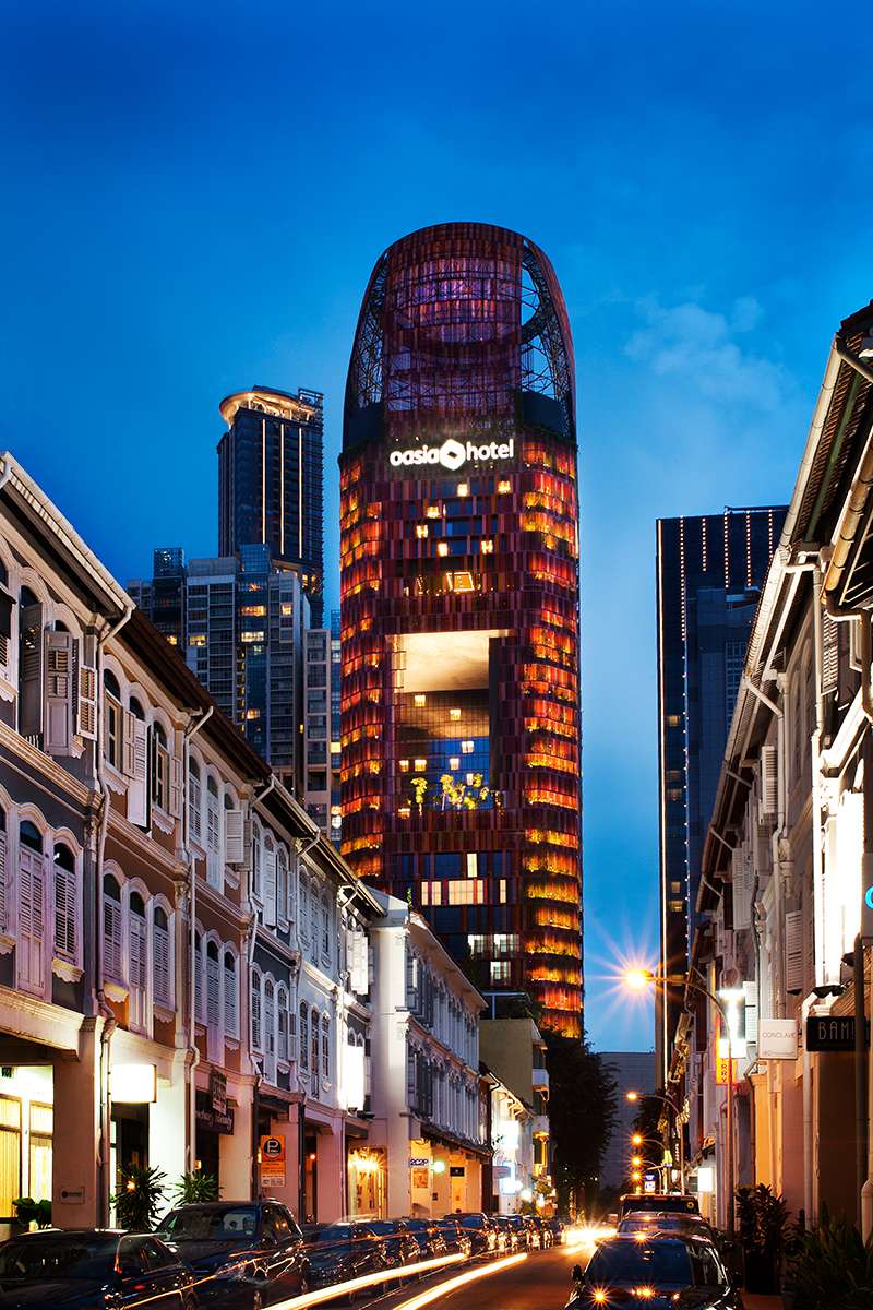 Oasia Hotel Downtown Singapore - Red building façade by shophouses, night view